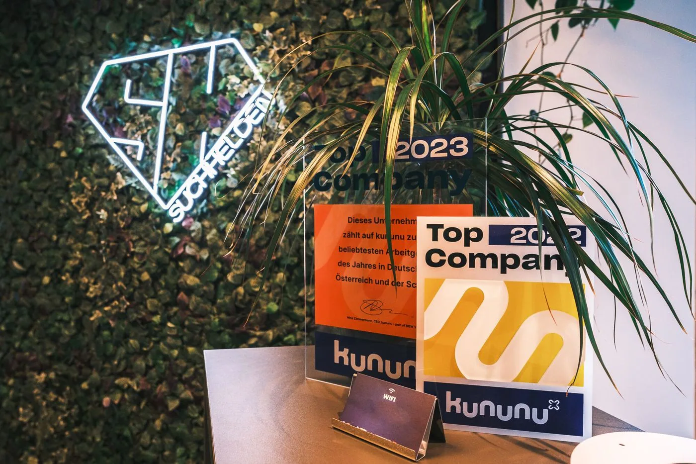 kununu-Top-Company-Siegel neben dem SH-Logo im Suchhelden-Büro in Osnabrück