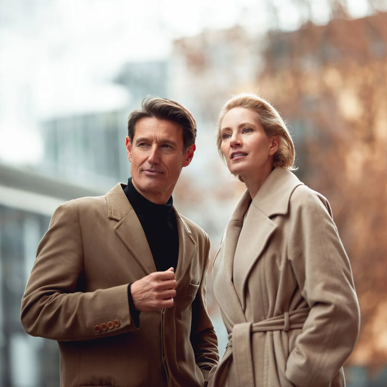 Mann und Frau mittleren Alters, die modern gekleidet durch die Stadt spazieren