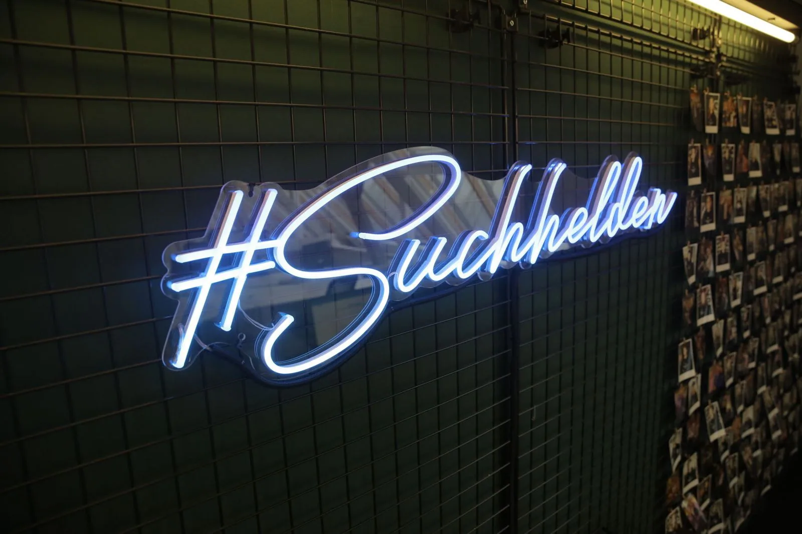 Neonschriftzug „#Suchhelden“ neben der Polaroid-Wand im Suchhelden-Büro in Osnabrück